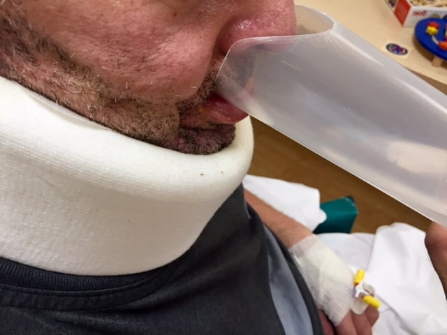 Paciente con disfagia del Instituto de Rehabilitación Neurológica de Hospitales VITHAS bebiendo en el vaso de plástico adaptado